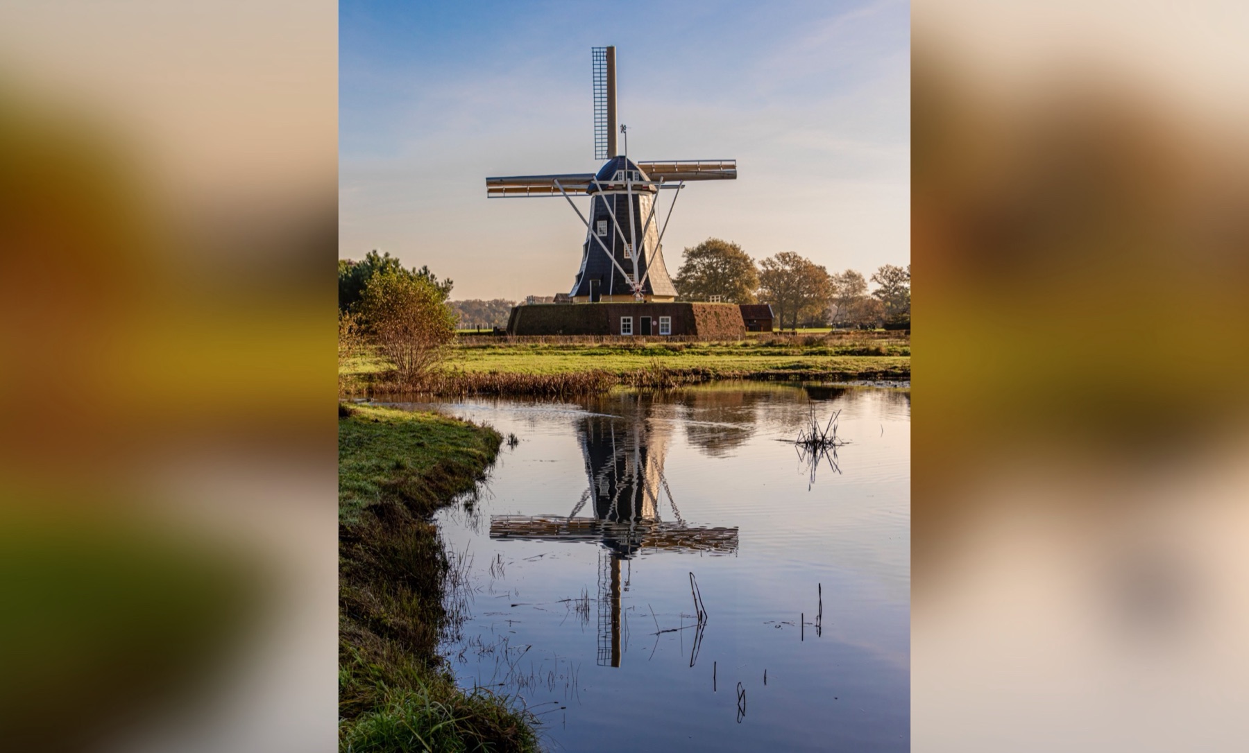 Het fotolijstje op een tablet: een staande foto van een molen met weerspiegeling in het water, met de randen ernaast vervaagd
